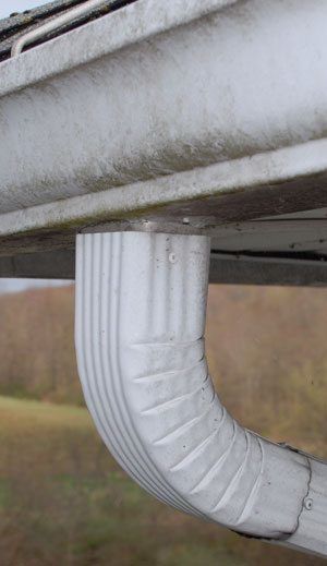 Three inch downspout that gets blocked with leaves easily. Bigger downspouts could help alleviate the problem.