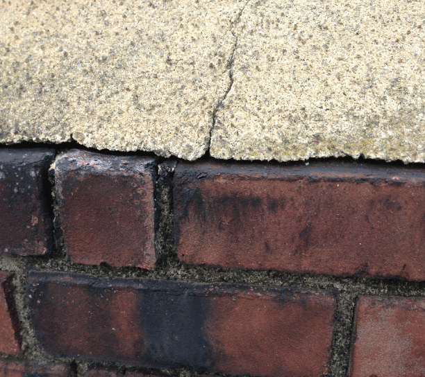 Chimney Leaks - When the cement slab separates from the bricks, water then can get inside the chimney busting the bricks during freezing.