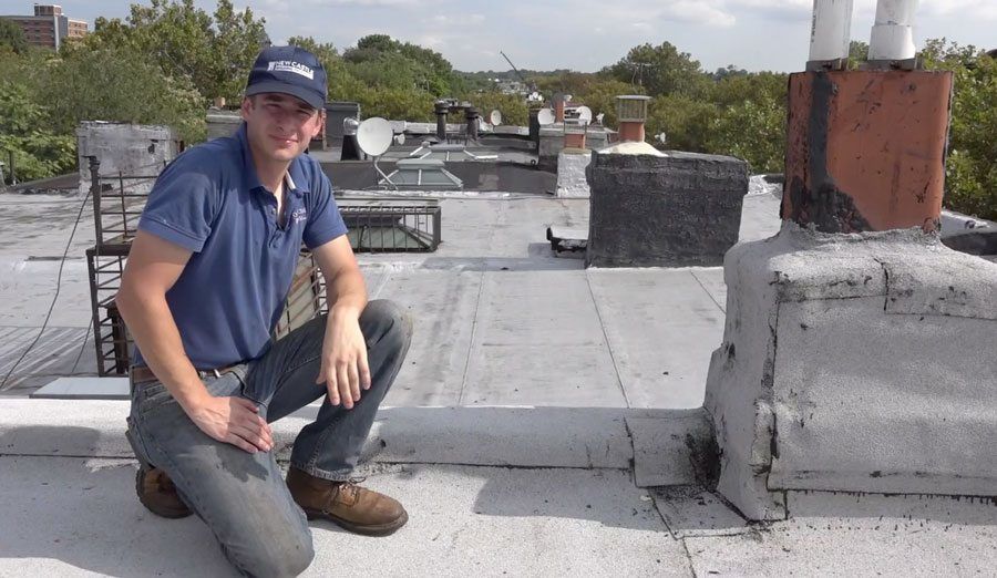 A Brownstone chimney is wrapped with rubber roof membrane.