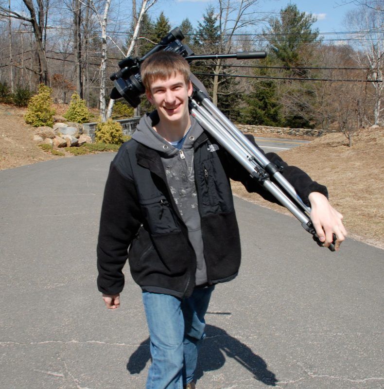 Erik carrying the cameras for video shooting on a roof