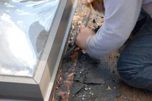 Flat Roof Repair - In this image we show the removing of roofing materials on the skylight flashing