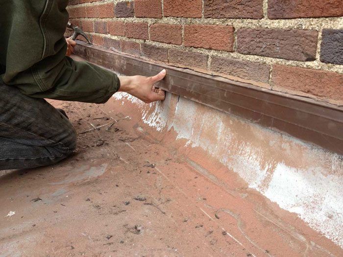 Flat roof repair - after installing cutting the grove in the brick wall, the counter flashing is installed