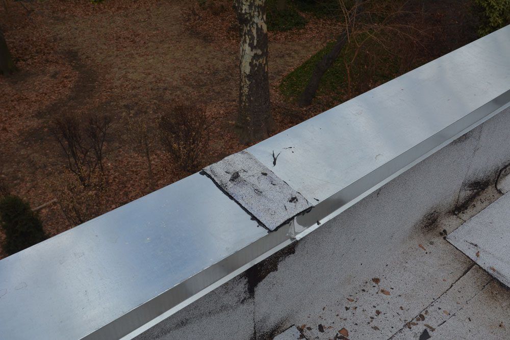 The transition where the two metal caps meet on the parapet wall was covered with a rubber membrane